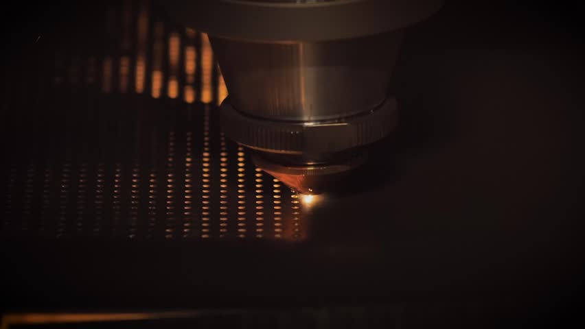 Automatic cnc laser cutting machine making holes in sheet metal with many sparks at factory, plant - slow motion, close up. Technology, metalworking, industrial, manufacturing and equipment concept