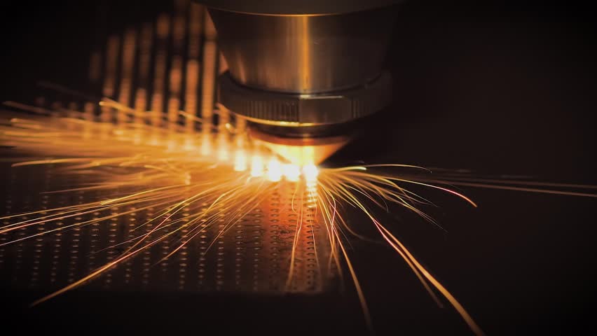 Automatic cnc laser cutting machine making holes in sheet metal with many sparks at factory, plant - slow motion, close up. Technology, metalworking, industrial, manufacturing and equipment concept