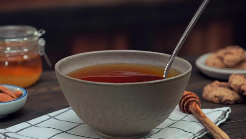 Honey dripping from spoon, macro food texture dessert syrup copy space