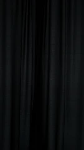 Young woman opening curtains and looking out the window