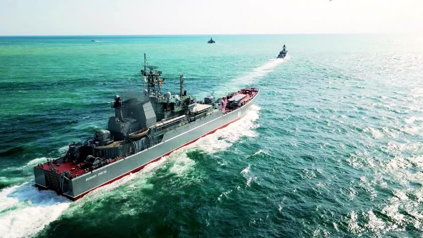 Expansive aerial view capturing naval military exercises at sea with a fleet of warships maneuvering in formation for strategic operations and readiness demonstrations