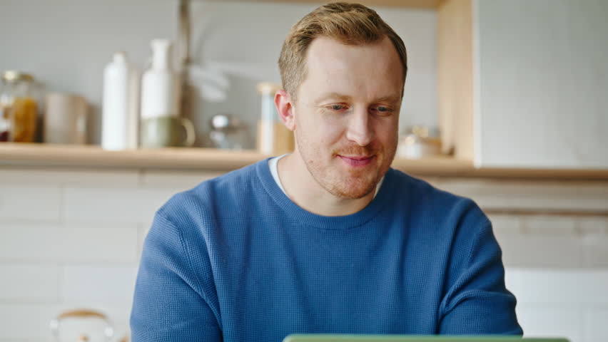 Freelancer greeting videocall waving hand laptop web camera closeup. Smiling remote manager start online meeting sitting apartment kitchen. Happy man talking computer enjoying virtual conference.