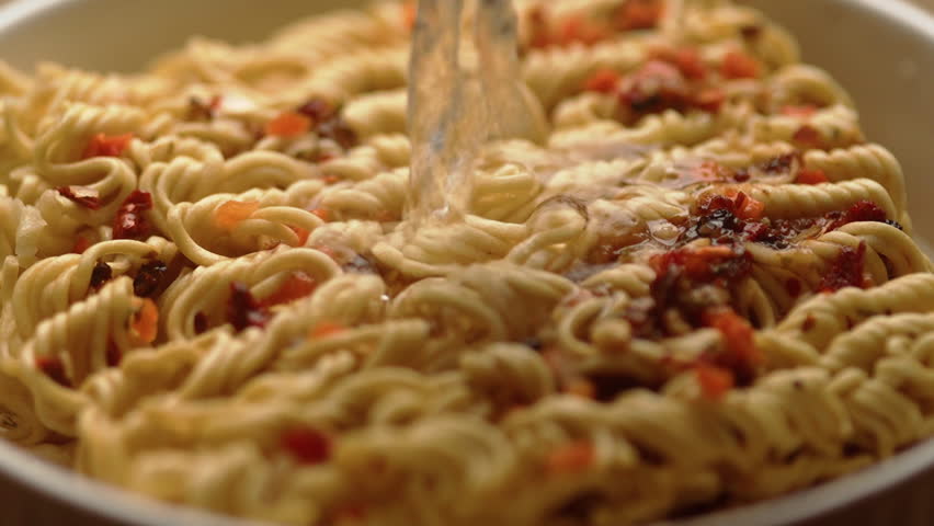 Slow motion. Cooking asian fast food. Hot water pouring into dry instant noodles