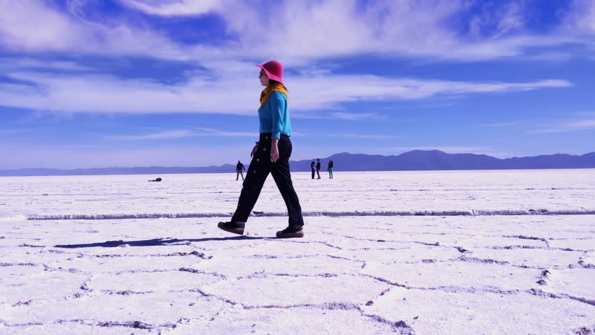 Woman in Colorful Outfit Walking Across Salinas Grandes Salt Flats, Jujuy, Northern Argentina - 4K