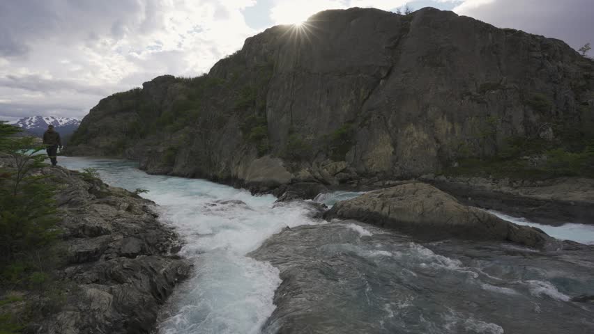 View of Azara Waterfall in Perito Moreno National Park with a man standing on the rocks in nature. Patagonia, Argentina