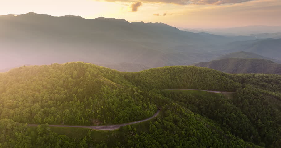 Winding mountain road in summer woods at sunset. Laurel Knob Overlook in Appalachian mountains in North Carolina with fresh green forest trees in summertime season. Beauty of USA nature