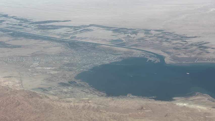 4k aerial video footage, flying across Egyptian Landscape, with Gulf of Suez, (Red Sea) City of Suez and southern entrance of Suez Canal - Sinai Peninsula desert landscape in the background 