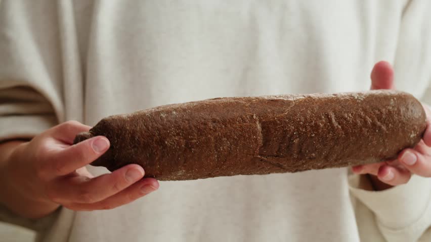 Black rye bread close up, dark brown sliced loaf, borodinsky slavic food, square slices with coriander on white background