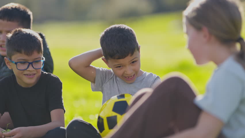 Children social group talking together in park after soccer game