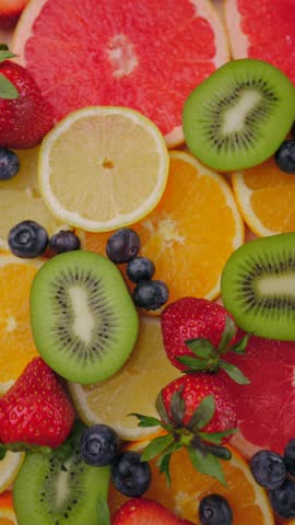 Background of fresh fruits and berries rotating. Vegan sweet food, flat lay.