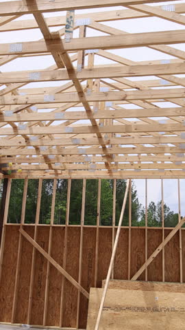 Wooden beams are being assembled to create roof structure of new building