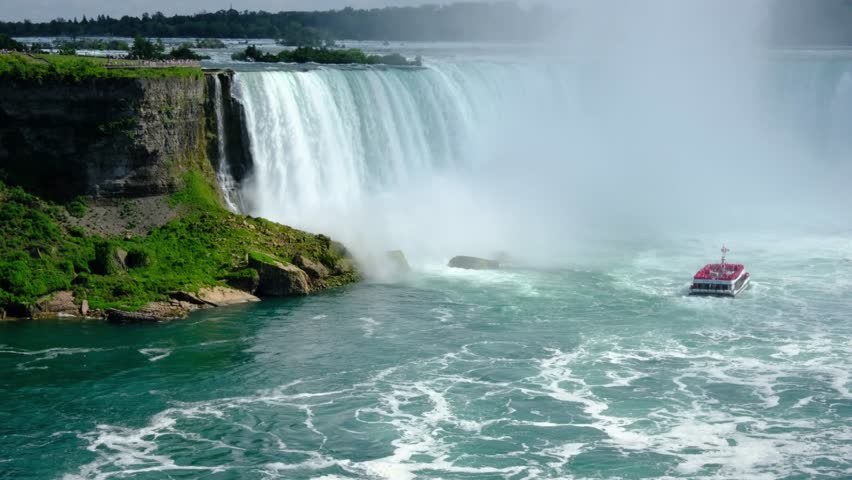 This 4K video captures a boat tour near the base of Horseshoe Falls at Niagara Falls. The visual documents the 50-meter vertical drop and the mist generated by the Niagara River flow. The composition illustrates the transit from Lake Erie to Lake Ontario, documenting fluvial geomorphology and maritime tourism for nature, travel, and editorial media.