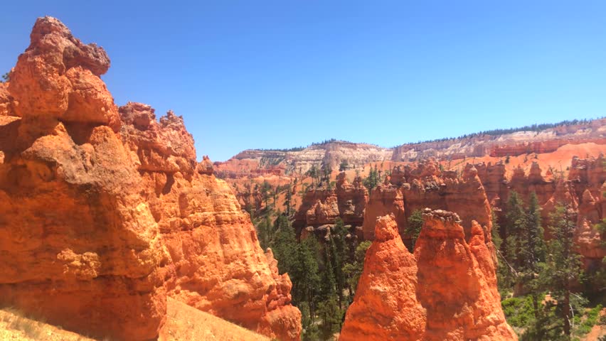 This 4K video captures Bryce Canyon National Park in Utah, USA. The visual documents thousands of hoodoos, which are tall, thin rock spires formed by frost wedging and erosion. The composition illustrates the large natural amphitheater of the Paunsaugunt Plateau, documenting Colorado Plateau geology and sedimentary rock layers for nature, travel, and editorial media.