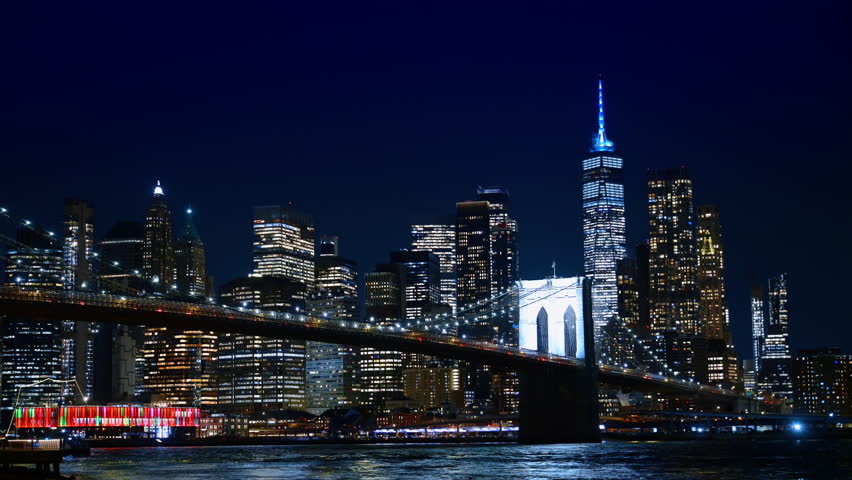 Brooklyn Bridge cables and Lower Manhattan night city lights. Night view of the Brooklyn Bridge suspension towers and cables against the Lower Manhattan skyline.