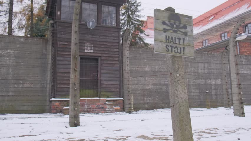 Auschwitz concentration camp warning sign and guard tower in winter