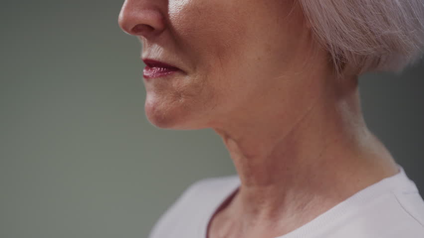 Elderly woman neck and good teeth smile. Old female tightens and stretches chin perfect skin. Care for senior persons medicine and treatment. Cosmetology or dermatology for wrinkles. Close up macro