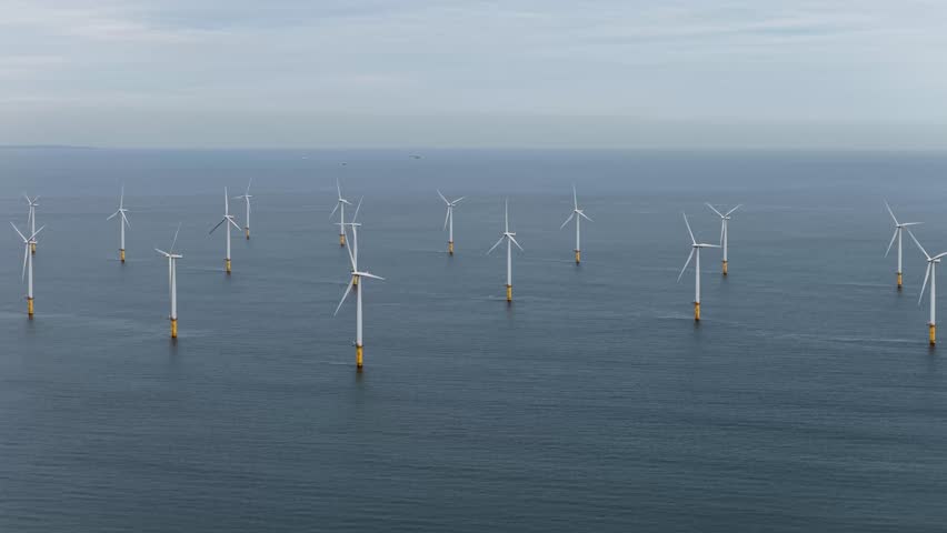 Aerial drone footage taken in the town of Middlesbrough in the UK showing wind turbines that are producing electricity on the ocean