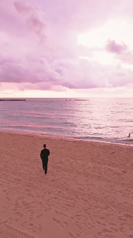 Businessman enjoying a peaceful solo walk on the beach at sunset