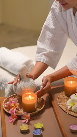Spa setup with herbal compress candles flowers and relaxing wellness mood.