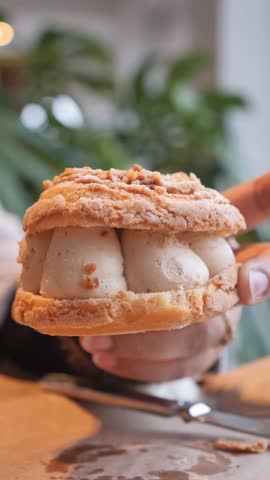 Close up motion footage capturing delicious cream puff dessert filled with scoops of ice cream