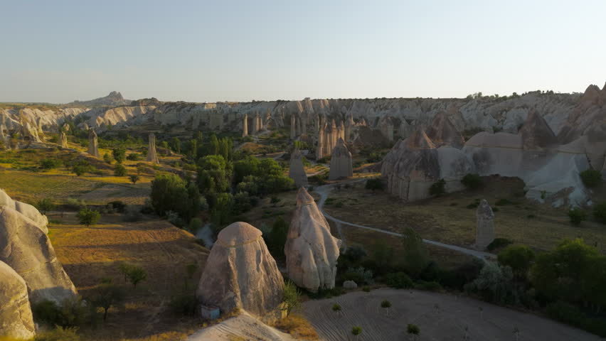 Goreme, Nevsehir, Turkey. Exploratory low flight over Love Valley terrain showing intricate details of trails and rock formations at dusk. Aerial View