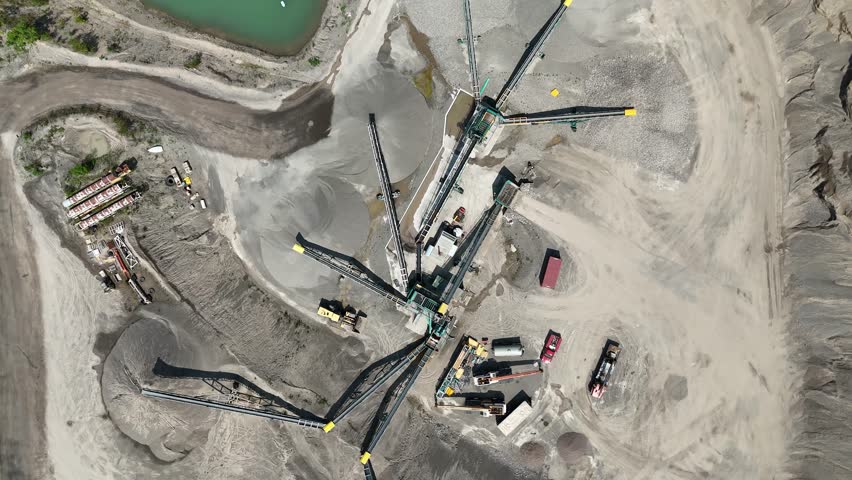 The gradients and curvatures of an active mining site are distinctly visible as heavy equipment operators continue to work to process raw materials.