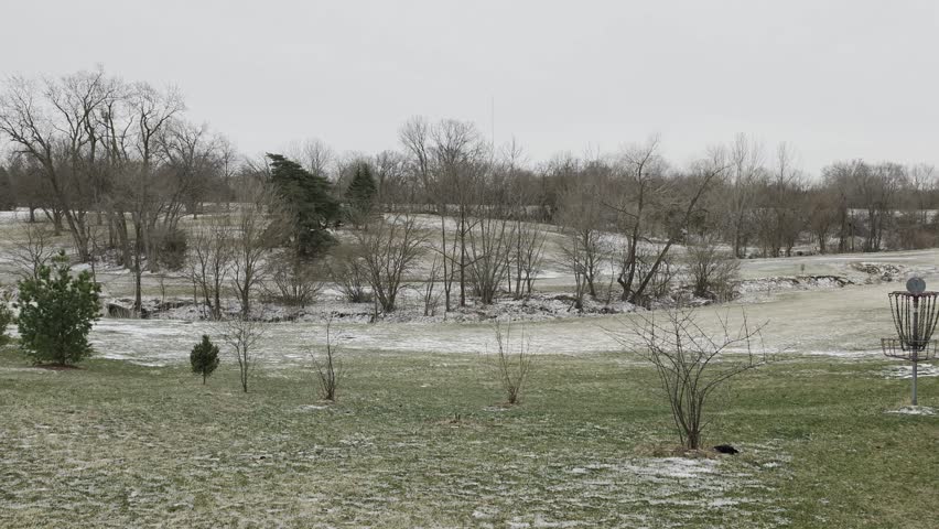 Snow blankets the playgrounds and shelters of Lions Park in Altoona, Iowa. Quiet walking paths wind through drifts of white, while bare trees stand tall against a crisp, Midwestern winter sky.