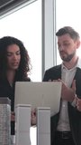 A diverse group of professionals collaborates around a laptop, discussing architectural models in a bright office setting - Powered by Shutterstock - Get 15% off with code: PIKWIZARD15