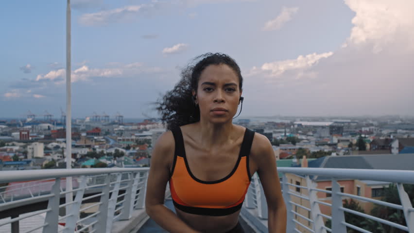 Fitness, running or person on bridge with earphones, cardio playlist or stamina exercise in speed activity. Fast, technology or woman with intense sprint, sports podcast or endurance workout in city.