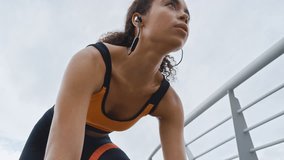 Woman, mark and start running in city with earphones, intense exercise or endurance training outdoor. Low angle, person or runner breathing on bridge with audio tech, begin sprint and cardio workout. - Powered by Shutterstock - Get 15% off with code: PIKWIZARD15