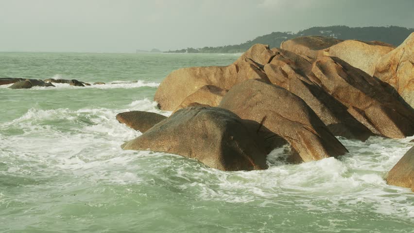 Coastal rocks with splashing water and foam.  