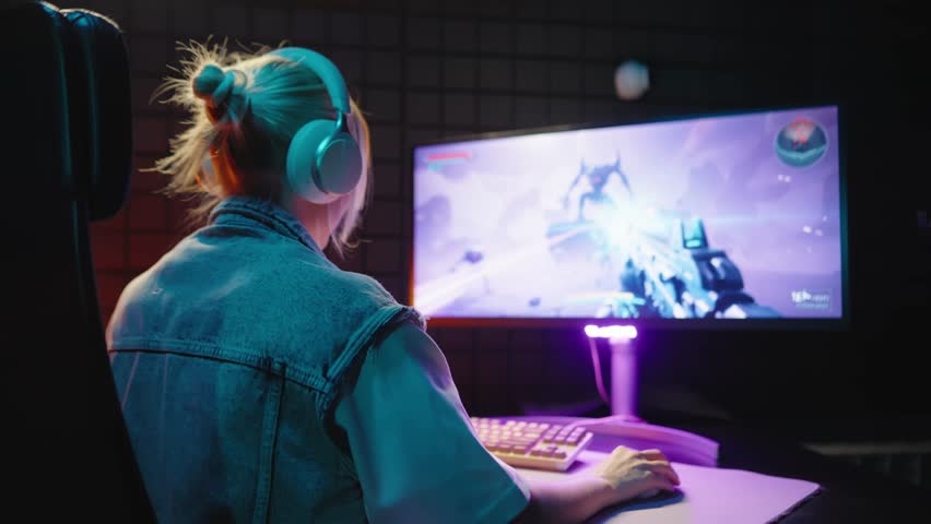 Young teen streamer gamer woman playing online video game on computer. Esport concept gaming virtual entertainment. E sport videogame tournament live stream. Tense female player cool girl competition.