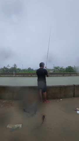 Fisherman Fishing by the Water on a Rainy Day