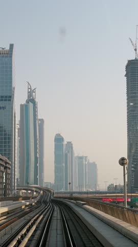 Dubai, UAE, United Arab Emirates . POV Subway train ride among modern skyscrapers in Dubai. Traffic On Street In Dubai. Monorail ride