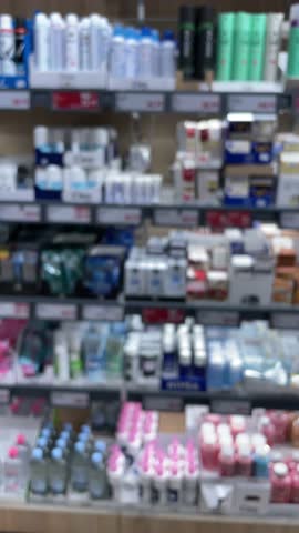 Personal care aisle with toiletries bottles, rows of shampoo, conditioner and lotion, pastel packaging and pump dispensers, organized