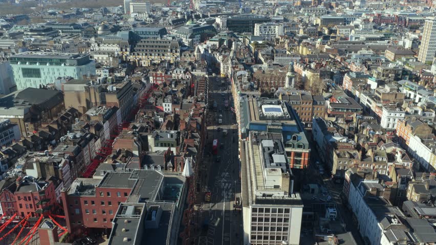 High street showing urban development and commercial properties in London's bustling West End, with historic buildings and modern architecture on a bright sunny day