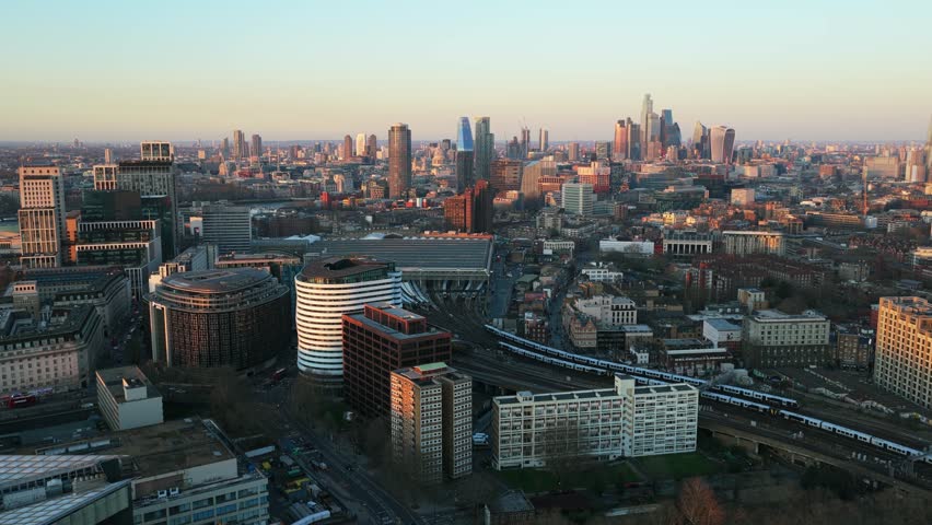 Aerial survey showing Waterloo station with trains arriving and the City of London skyline during a winter sunset over United Kingdom
