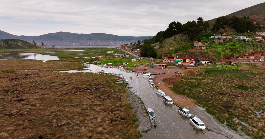 Docked boats along Lake Titicaca waterway at famous Uros floating islands, Peru