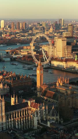 London's Westminster Abbey, River Thames, and skyline with Big Ben and London Eye showing city centre during a golden hour sunset in vertical