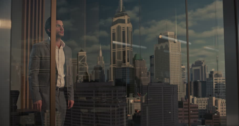 White Businessman in a Gray Suit Stands in a High-rise Office, Thinking Through Startup Strategy and Financial Growth With Confidence, Embodying Entrepreneurship, Ambition and Success in the City