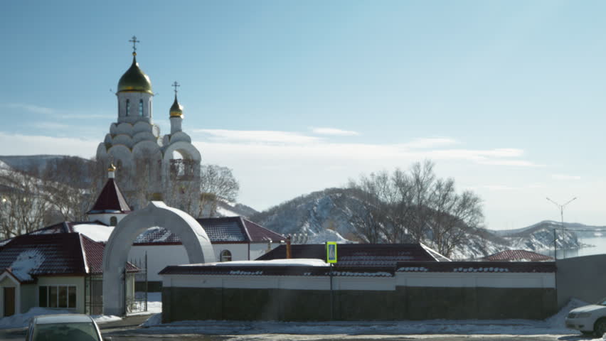 Orthodox church with golden dome standing in snowy winter landscape