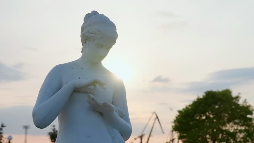 Serene Marble Figure Scene. Peaceful Park Setting Featuring Female Marble Sculpture At Sunset. Creative