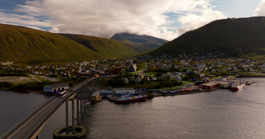 Tromsø city, bridge, and the iconic Arctic Cathedral during the autumn season in Norway. Aerial drone panoramic view