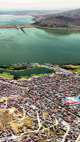 Vertical drone view of Mirador Punta de Puno with panoramic view of Lake Titicaca in Peru. Scenic landscape and popular travel destination in South America.	