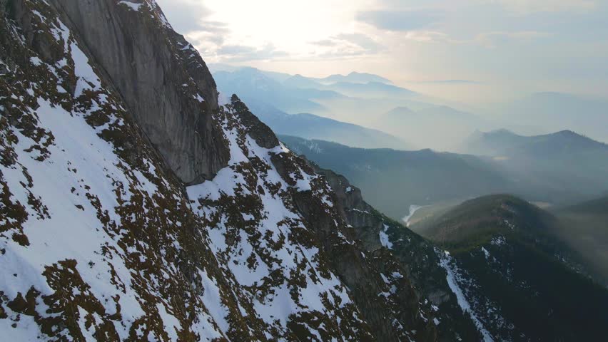 Mountain landscape and vast valleys. Cloudscape over snow-capped cliffs. Alaska, USA.