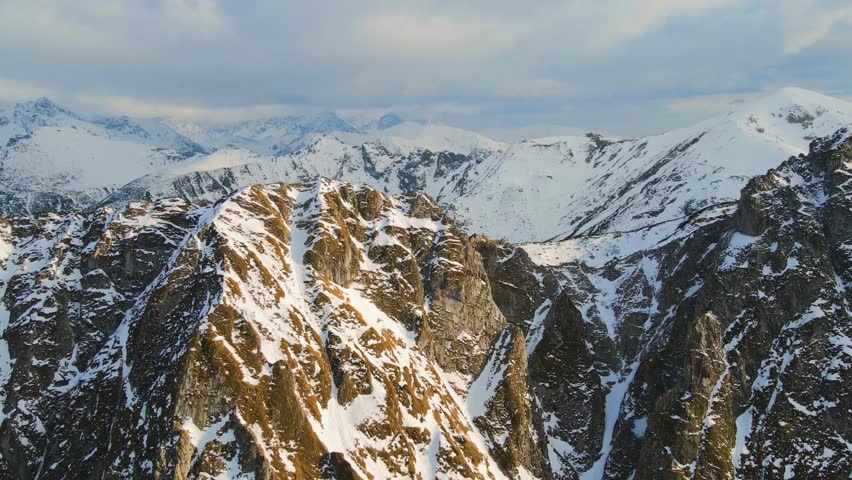 Mountain landscape and vast valleys. Cloudscape over snow-capped cliffs. Alaska, USA.