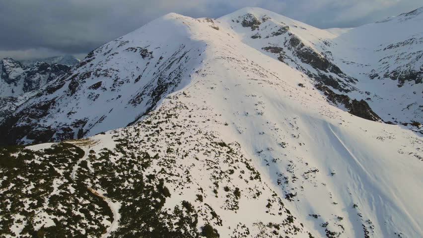 Mountain landscape and vast valleys. Cloudscape over snow-capped cliffs. Alaska, USA.