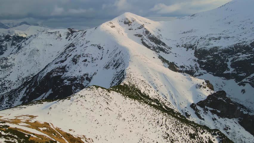 Mountain landscape and vast valleys. Cloudscape over snow-capped cliffs. Alaska, USA.