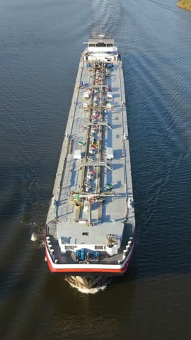 Efficient crude oil transport through serene waterways in the energy industry. Vertical video