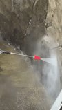 Worker cleaning stone wall with pressure washer removing dirt and algae in outdoor maintenance work. Worker cleans building exterior using a pressure washer.  Vertical video - Powered by Shutterstock - Get 15% off with code: PIKWIZARD15
